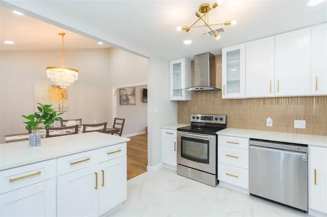 a kitchen with white cabinets and appliances