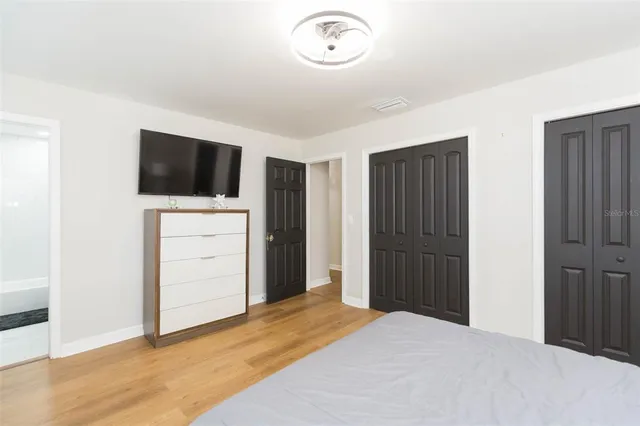 a bedroom with a bed and a flat screen tv