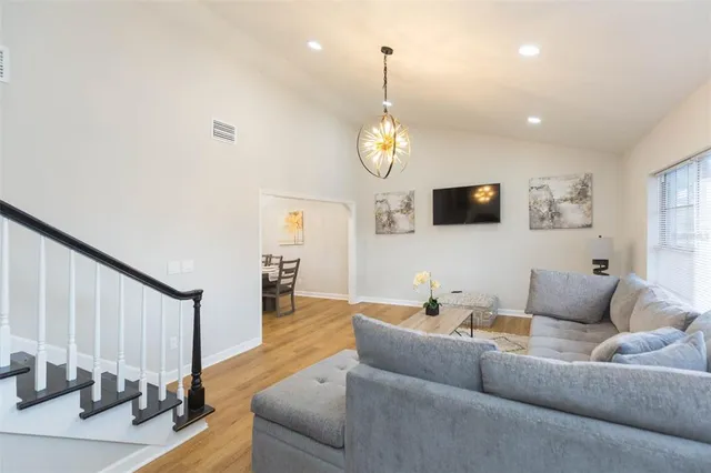 a living room with furniture wooden floor and a chandelier