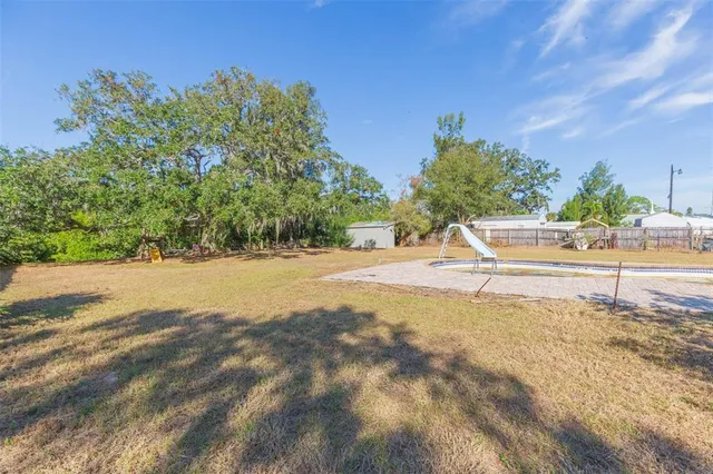 a view of dirt field with trees in the background