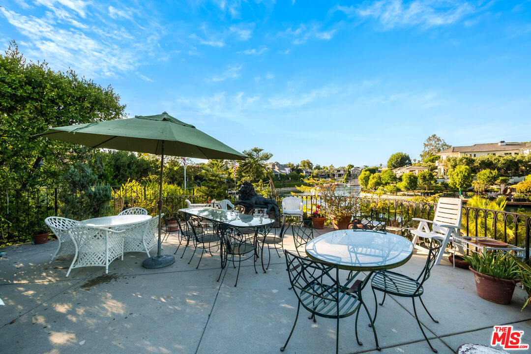 10061 Valley Spring Lane Toluca Lake, CA 91602 - Photo 23 of 37 a view of a patio with chairs and table under an umbrella