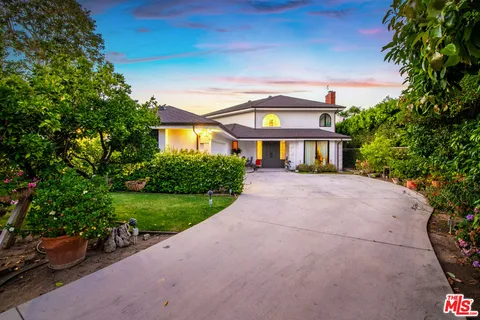 a front view of a house with a yard and a garden