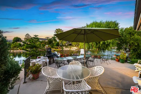 a view of a patio with couches table and chairs and potted plants