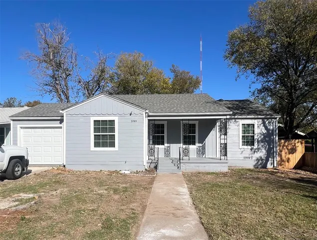 a front view of a house with a yard covered with snow