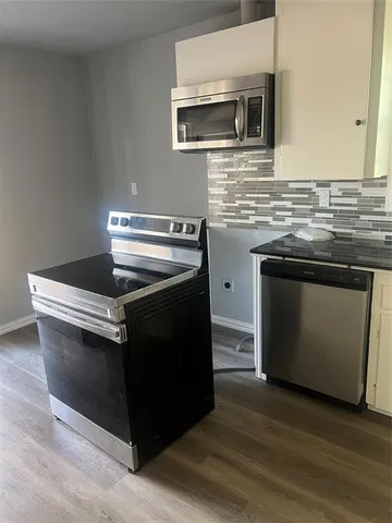 a kitchen with stainless steel appliances granite countertop a stove and a microwave