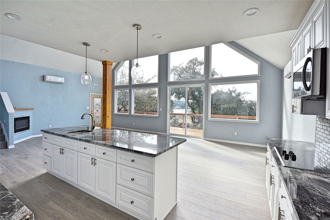 a large kitchen with kitchen island granite countertop a large window and a sink