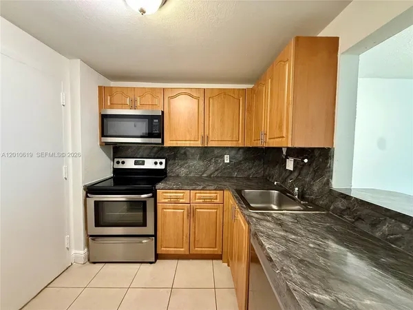 a kitchen with stainless steel appliances a stove a sink and a microwave