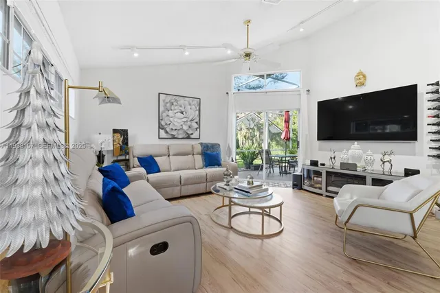 a living room with furniture a flat screen tv and a chandelier