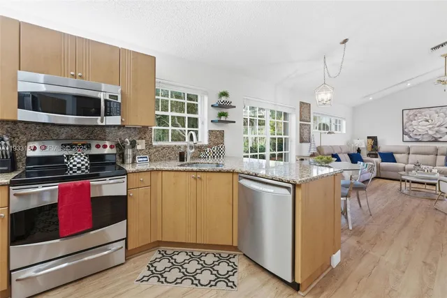 a kitchen with stainless steel appliances granite countertop a stove and a sink