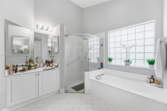 a bathroom with a bathtub a sink a window and shower