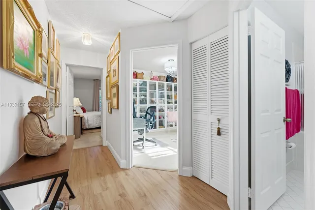 a view of a hallway with wooden floor and furniture