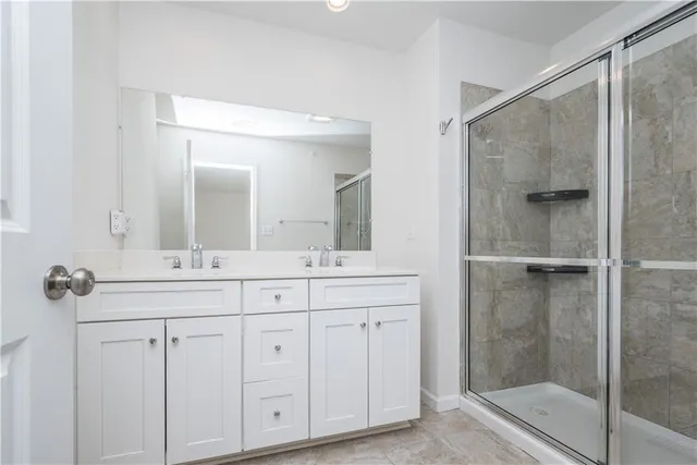 a bathroom with a double vanity sink mirror and shower