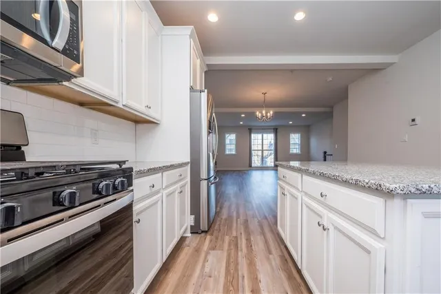 a kitchen with stainless steel appliances granite countertop a stove and a refrigerator