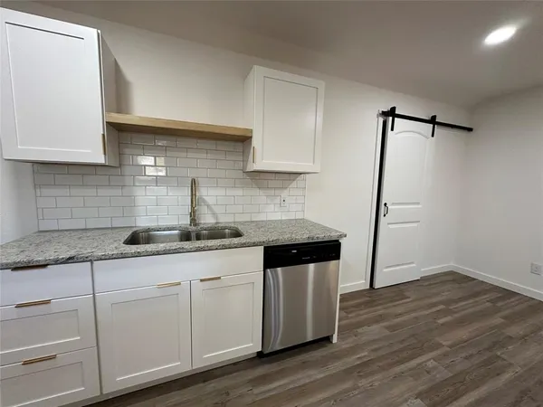 a kitchen with stainless steel appliances granite countertop a stove top oven a sink a microwave and a refrigerator