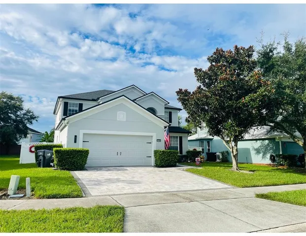 a front view of a house with a yard and trees