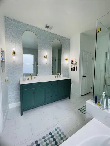 a bathroom with a double vanity sink mirror and bathtub