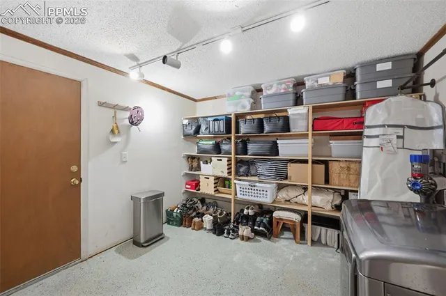 a living room with stainless steel appliances kitchen island a refrigerator a stove and a cabinets