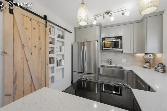 a kitchen with stainless steel appliances a sink stove refrigerator and microwave