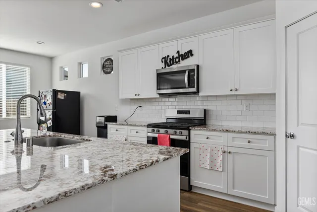 a kitchen with stainless steel appliances granite countertop a sink stove and microwave