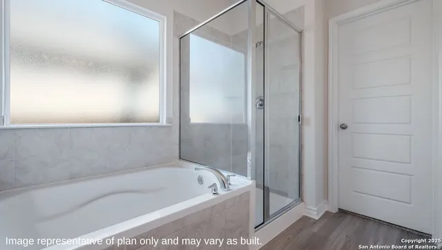 a bathroom with a tub a mirror and a shower