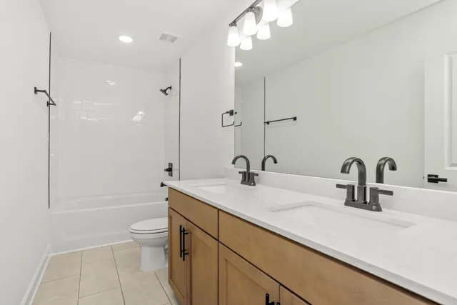 a bathroom with a sink a toilet a mirror and shower