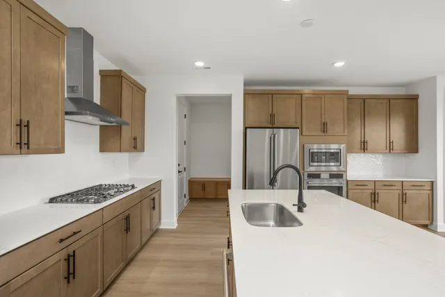 a kitchen with stainless steel appliances granite countertop a sink stove and cabinets