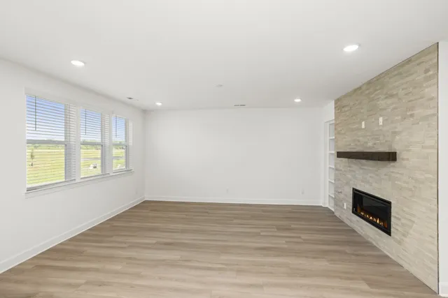 an empty room with wooden floor and fireplace
