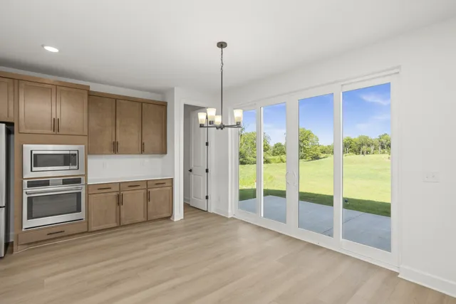 a kitchen with kitchen island wooden floor appliances and a counter top space