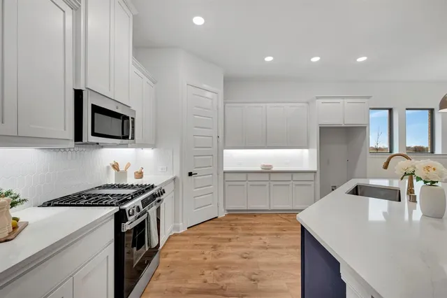 a kitchen with a sink stove top oven and cabinets