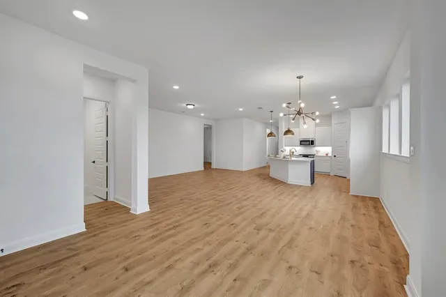 a view of a big room with wooden floor and windows