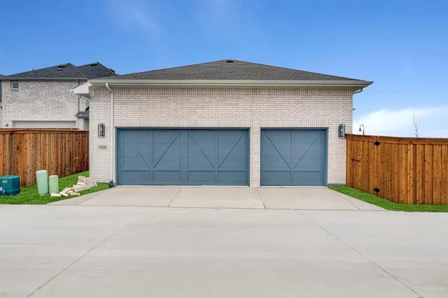 a front view of a house with garage and garden