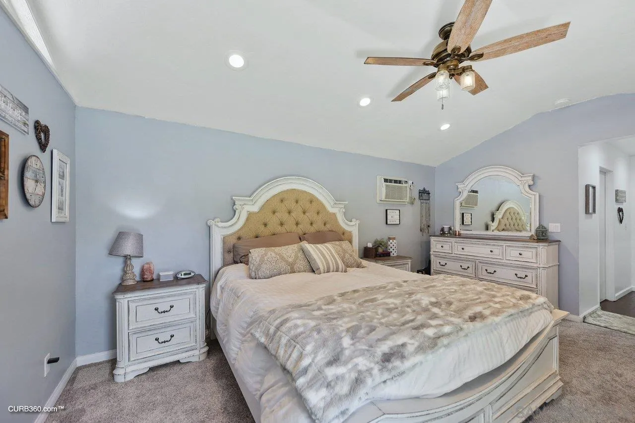 13429 Standish Drive Poway, CA 92064 - Photo 17 of 30 a bedroom with a large bed and a chandelier