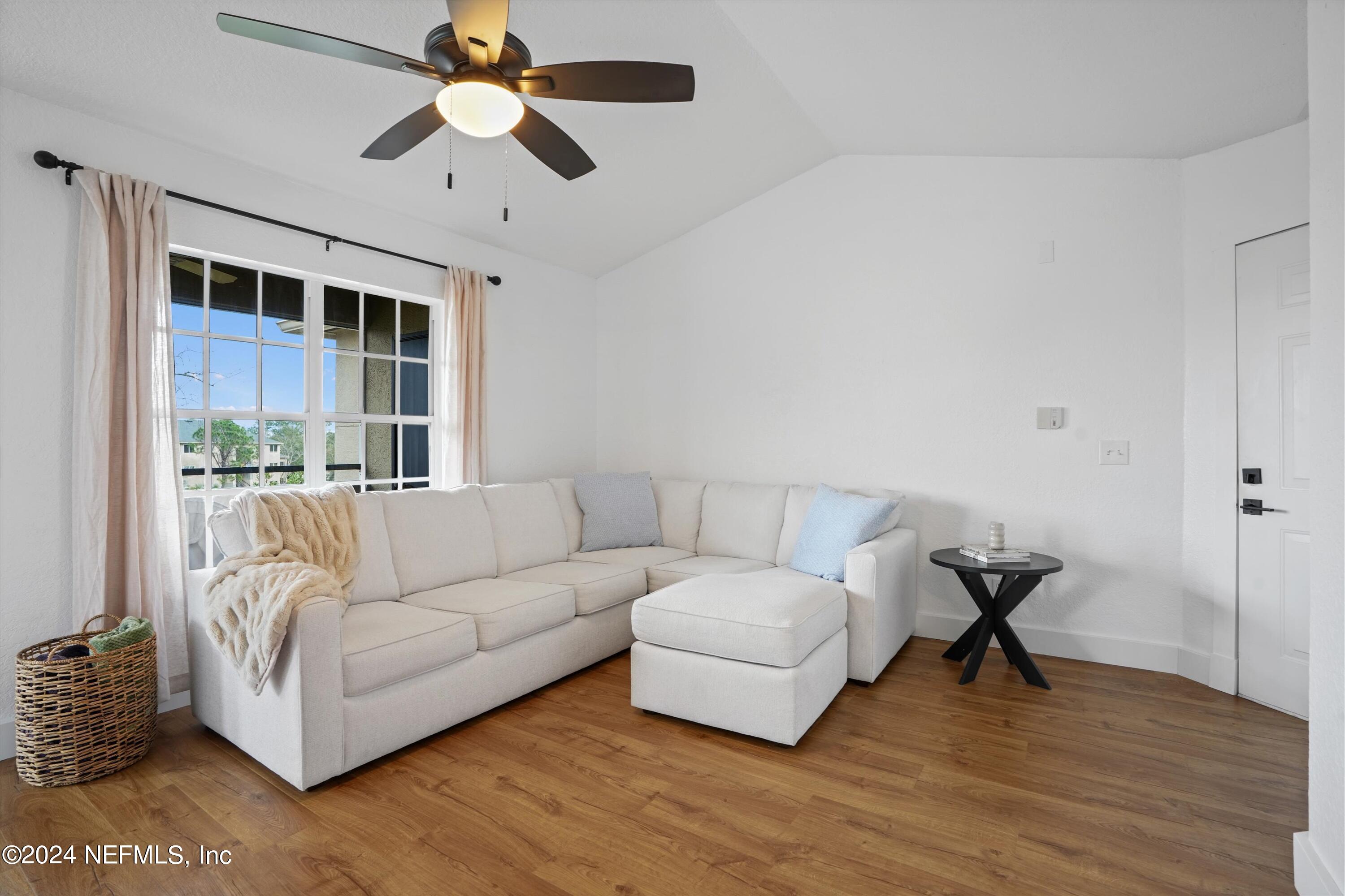 a living room with furniture and a ceiling fan