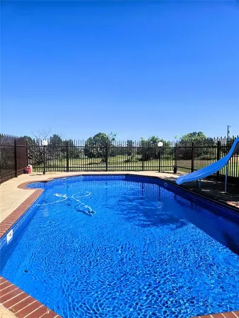 a view of swimming pool with outdoor seating and yard