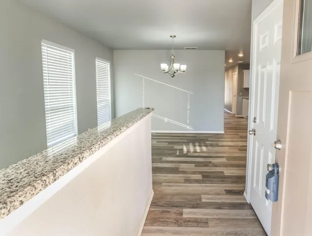 a view of a hallway with wooden floor and staircase