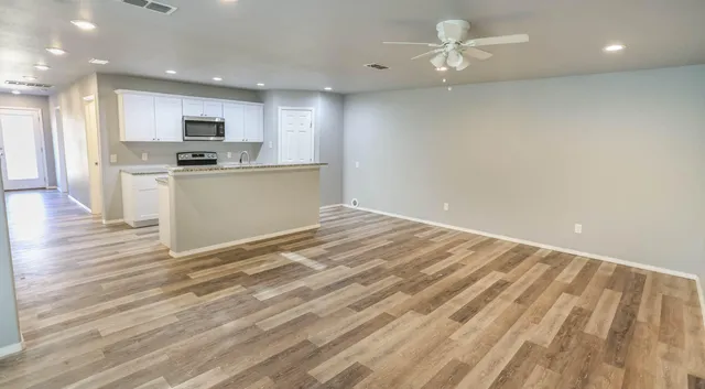 a view of kitchen with granite countertop cabinets and refrigerator
