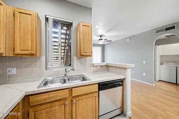 a kitchen with stainless steel appliances granite countertop a sink and dishwasher refrigerator stove with wooden floor