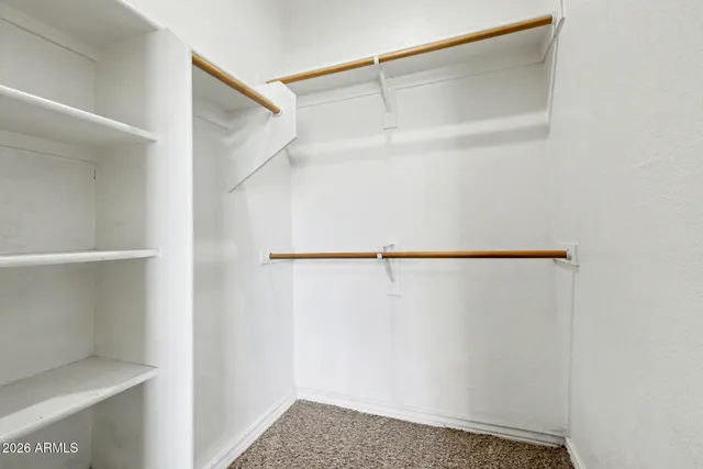 a view of walk in closet with empty racks