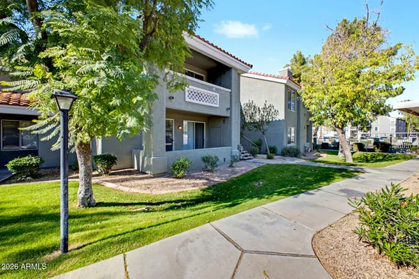 a front view of a house with a garden and tree