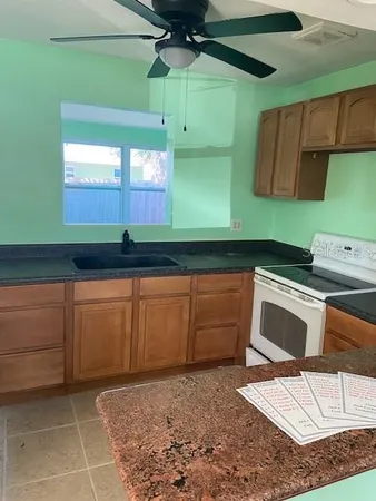 a kitchen with granite countertop a cabinets a sink and a stove