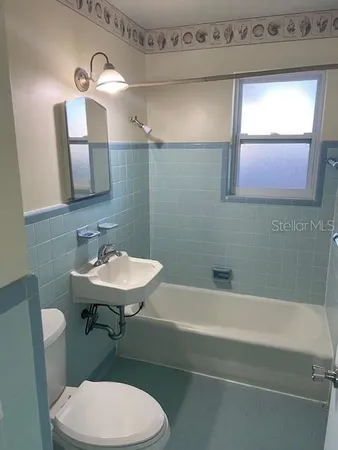 a bathroom with a sink a toilet and mirror