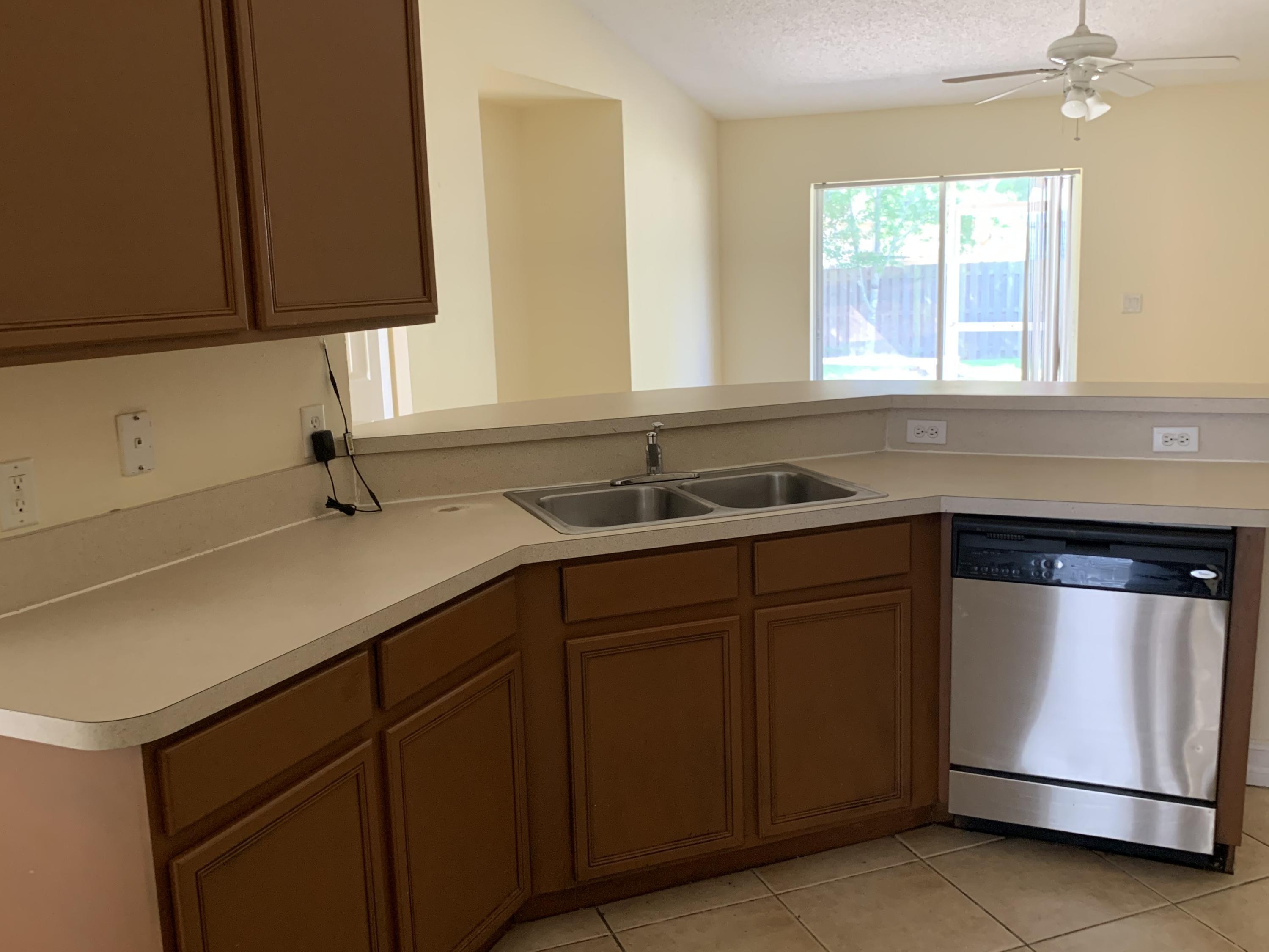 269 Southwest Ridgecrest Drive Port St. Lucie, FL 34953 - Photo 14 of 24 a kitchen with a sink and cabinets