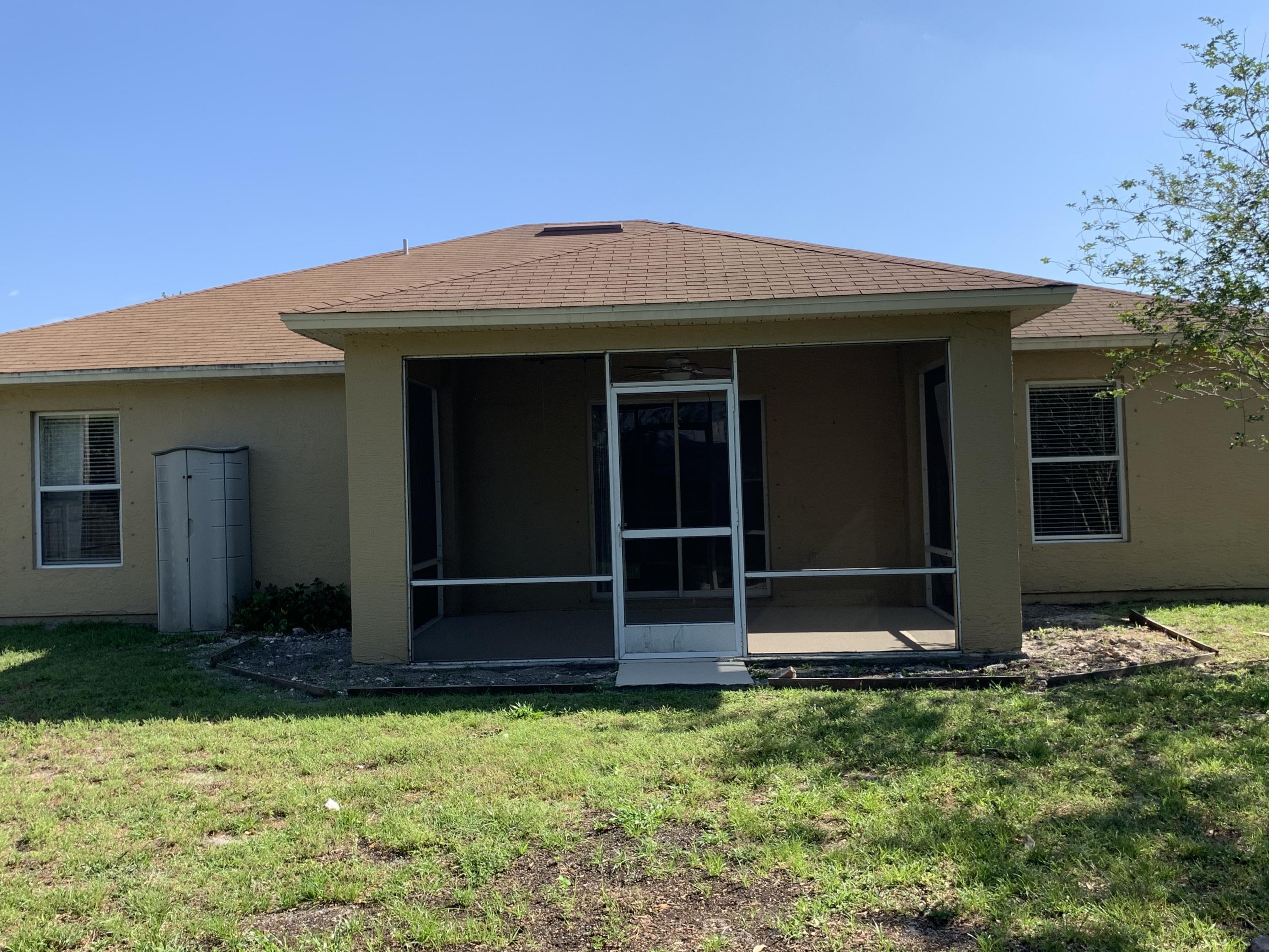 269 Southwest Ridgecrest Drive Port St. Lucie, FL 34953 - Photo 20 of 24 front view of a house with a yard