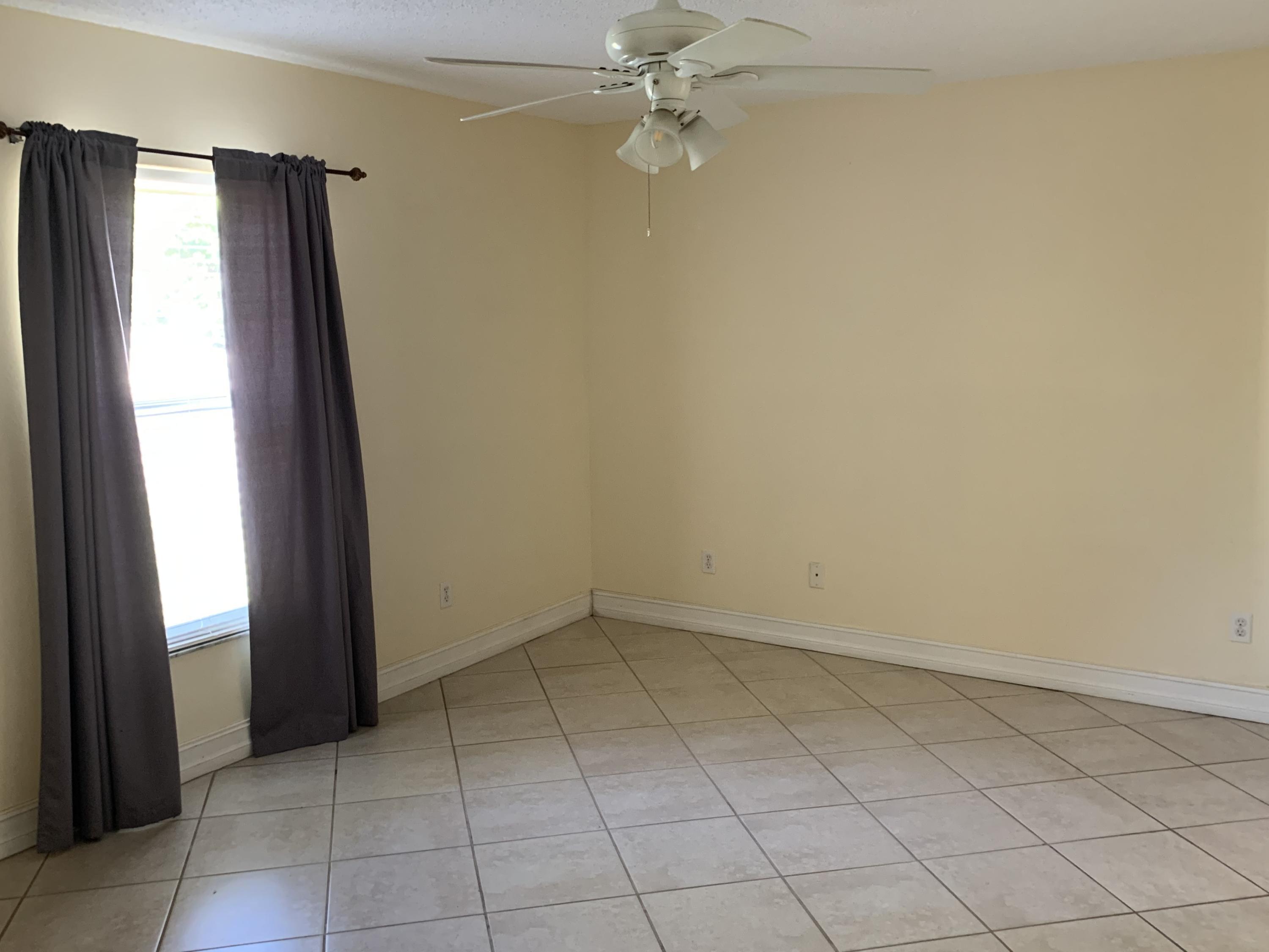 269 Southwest Ridgecrest Drive Port St. Lucie, FL 34953 - Photo 10 of 24 an empty room with windows and fan