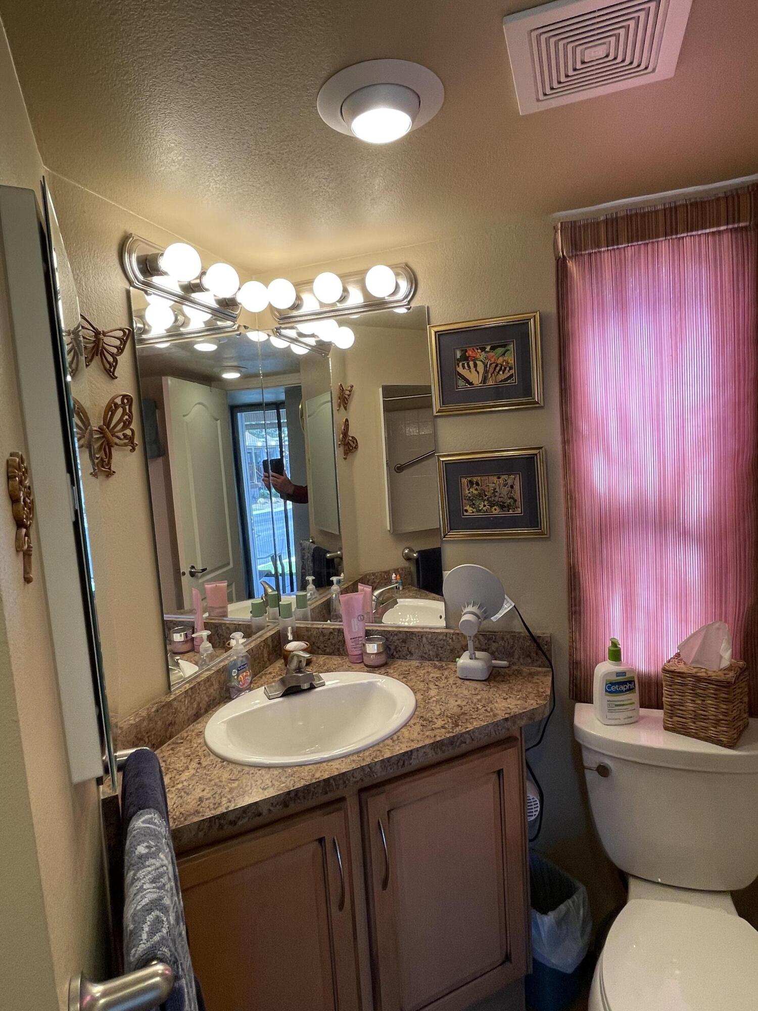 81620 Ave 49, Unit 235B Indio, CA 92201 - Photo 4 of 21 a bathroom with a granite countertop sink a toilet and a mirror