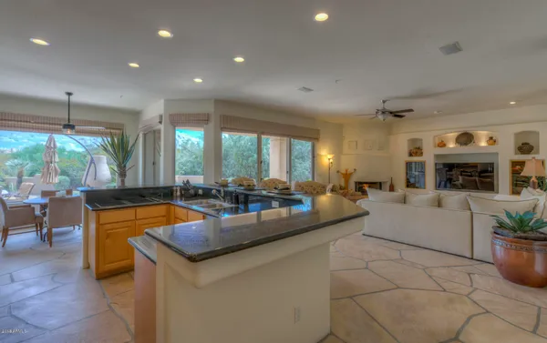 a large living room with stainless steel appliances granite countertop a couch and a fireplace