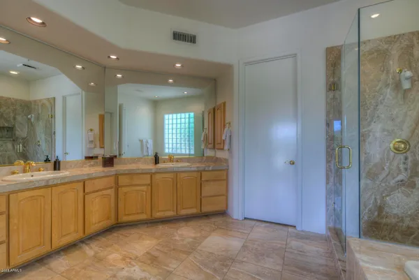 a large bathroom with a large mirror vanity and shower