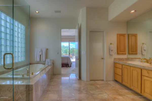 a bathroom with a tub a sink and a mirror