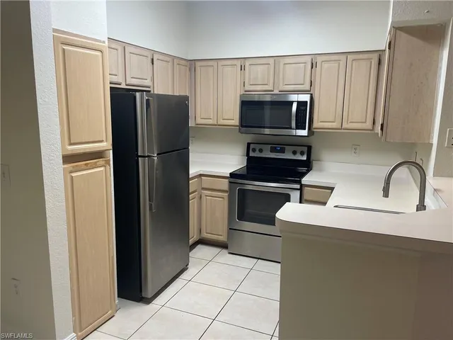 a kitchen with stainless steel appliances a refrigerator stove microwave and sink