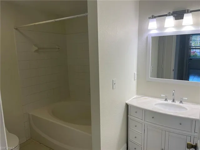 a bathroom with a granite countertop sink a toilet and shower